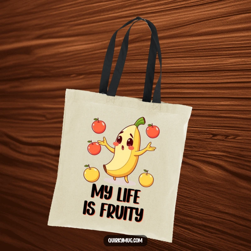 Funny tote bag depicting a surprised banana character slipping on its own peel while juggling apples.